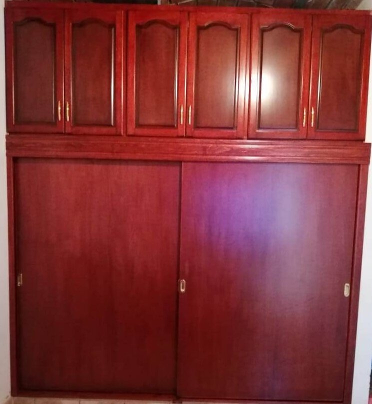 Vestidor con isla central y acabados en madera de parota en hogar de El Palomar