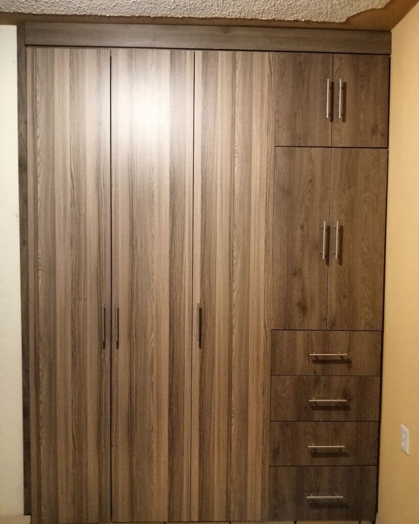 Closet de madera natural con diseño minimalista en dormitorio de Providencia, Guadalajara.