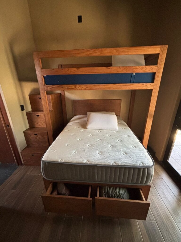 Cama de madera de encino con base flotante en habitación de Valle Real.