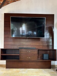Mueble de TV flotante con acabado en nogal y repisas empotradas en Puerta de Hierro.