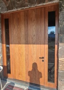 Puerta de acceso de madera y vidrio con herrajes de alta gama en propiedad de Monraz, Guadalajara.