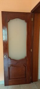 Puerta de acceso con detalles en acero inoxidable y madera en propiedad de El Palomar, Tlajomulco.