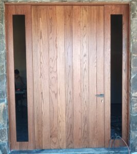 Puerta de entrada estilo colonial con detalles artesanales en hogar de Country Club, Guadalajara.