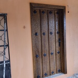 Puerta principal con acabados en caoba y detalles en hierro en casa de La Loma, Zapopan.